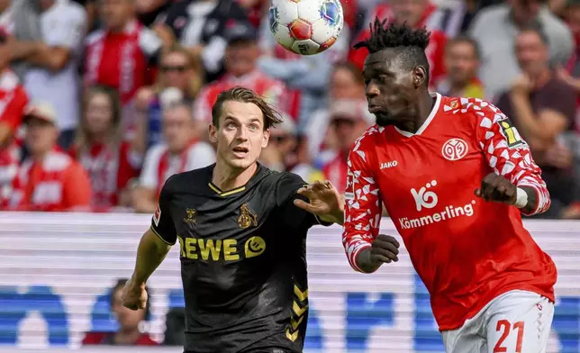 Mainz's Danny da Costa, right, plays against Cologne's Jakub Kaminski during the German Bundesliga soccer match between Mainz and Cologne at the Mewa Arena in Mainz, Germany, Sunday, Aug. 24, 2025. (Torsten Silz/dpa via AP)