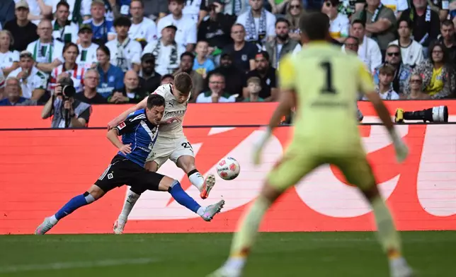 Hamburg's Giorgi Gocholeishvili, left, in a duel with Borussia's Lukas Ullrich during the German Bundesliga soccer match between Borussia Mönchengladbach and Hamburger SV at Borussia-Park in Mönchengladbach, Germany, Sunday Aug. 24, 2025. (Fabian Strauch/dpa via AP)