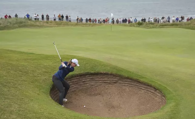 Lottie Woad of England plays out of a bunker on the 1st green during the third round of the Women's British Open golf championship, at Royal Porthcawl Golf Club in Porthcawl, Wales, Saturday, Aug. 2, 2025. (AP Photo/Kin Cheung)