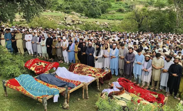 People attend funeral prayers of the victims of cloudburst incident, in Salarzai, Pakistan, Friday, Aug. 15, 2025. (AP Photo/Anwarullah Khan)