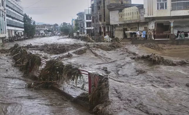 Local residents look at flash flooding due to heavy rains in a neighborhood of Mingora, the main town of Swat Valley, northwestern Pakistan, Friday, Aug. 15, 2025. (AP Photo/Naveed Ali)