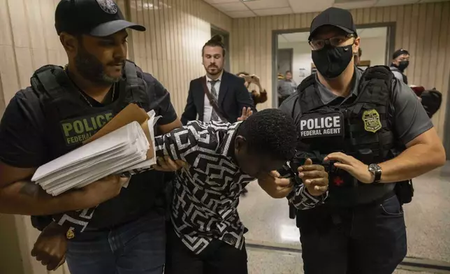 FILE - Federal agents including Immigration and Customs Enforcement detain a person outside an immigration courtroom at the Jacob K. Javits Federal Building in New York, Tuesday, June 10, 2025. (AP Photo/Yuki Iwamura, File)