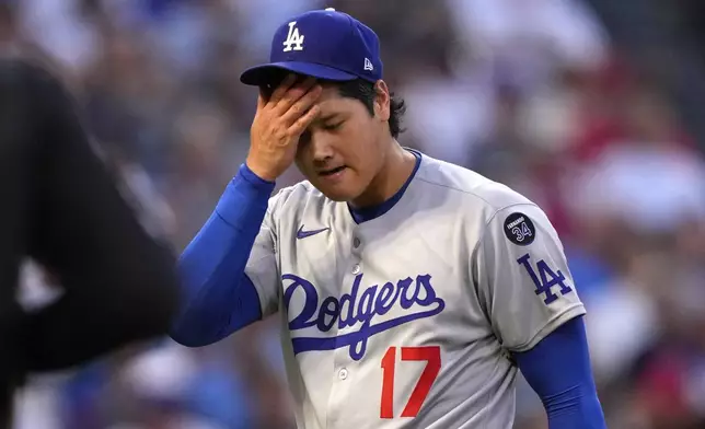 Los Angeles Dodgers starting pitcher Shohei Ohtani wipes his face after the third inning during of a baseball game against the Los Angeles Angels, Wednesday, Aug. 13, 2025, in Anaheim, Calif. (AP Photo/Mark J. Terrill)
