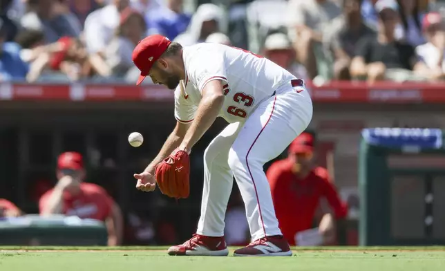 Los Angeles Angels relief pitcher Chase Silseth tries to field a ball during the sixth inning of a baseball game against the Chicago Cubs Sunday, Aug. 24, 2025, in Anaheim, Calif. (AP Photo/Eric Thayer)