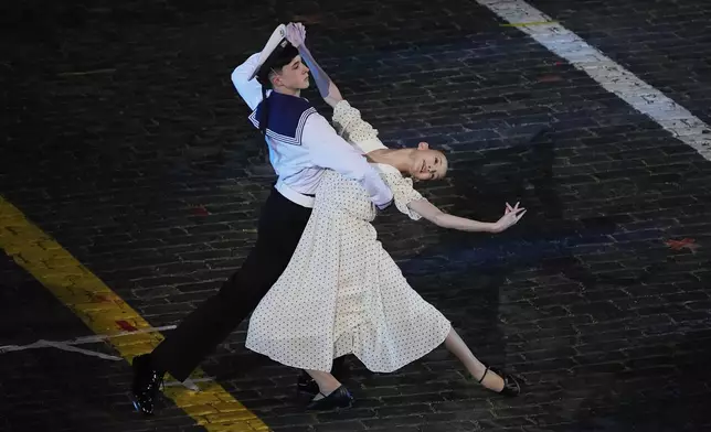 Actors ain 1950s clothing perform during a dress rehearsal of the Spasskaya Tower International Military Music Festival on the Red Square in Moscow, Thursday, Aug. 21, 2025. (AP Photo/Alexander Zemlianichenko)