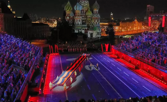 Russian soldiers carry a giant St. George ribbon, a symbol of Soviet participation in World War II, during the Spasskaya Tower International Military Music Festival in Red Square in front of the St. Basil Cathedral in Moscow, Russia, on Thursday, Aug. 21, 2025. (AP Photo/Alexander Zemlianichenko)