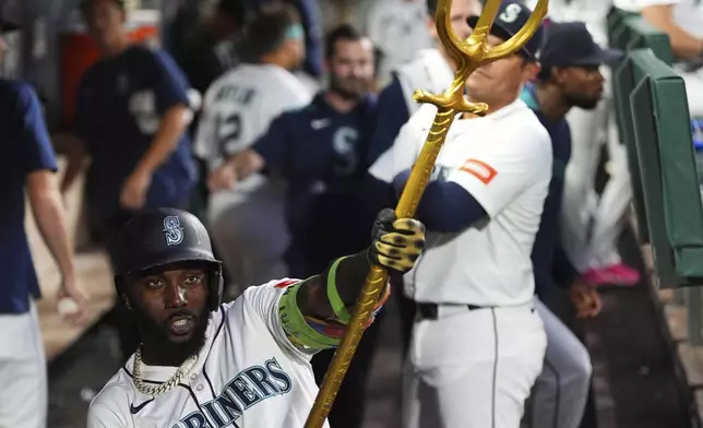 Seattle Mariners' Randy Arozarena celebrates with the trident in the dugout after hitting a solo home run against the Athletics during the sixth inning of a baseball game Saturday, Aug. 23, 2025, in Seattle. (AP Photo/Lindsey Wasson)
