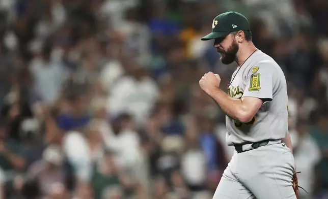 Athletics pitcher Hogan Harris reacts to earning the save in the 10th inning against the Seattle Mariners in a baseball game Saturday, Aug. 23, 2025, in Seattle. (AP Photo/Lindsey Wasson)