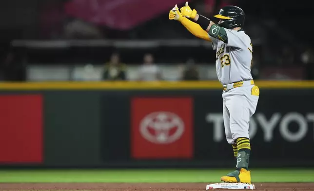 Athletics' Shea Langeliers celebrates his RBI double against the Seattle Mariners during the 10th inning of a baseball game Saturday, Aug. 23, 2025, in Seattle. (AP Photo/Lindsey Wasson)