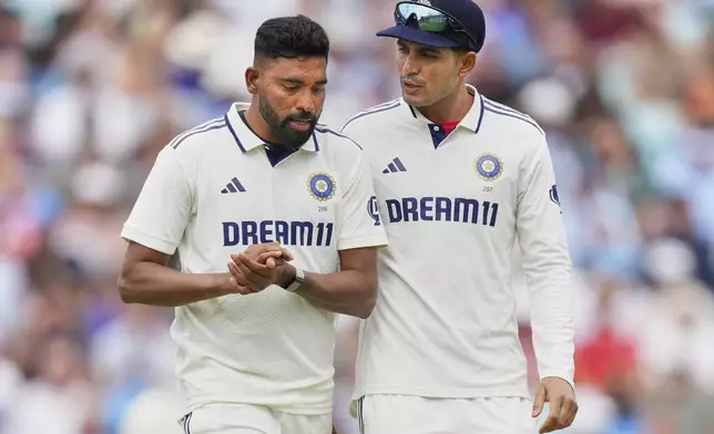 India's captain Shubman Gill, right, talks to India's Mohammed Siraj before bowls a delivery during the second day of the fifth cricket test match between England and India at The Kia Oval in London, Friday, Aug. 1, 2025. (AP Photo/Kirsty Wigglesworth)