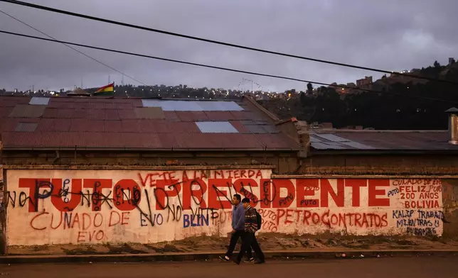 A man walks past a campaign sign for presidential candidate Jorge "Tuto" Quiroga prior to Sunday's presidential and legislative elections in El Alto, Bolivia, Thursday, Aug. 14, 2025. (AP Photo/Juan Karita)