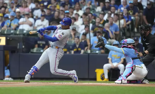 New York Mets' Juan Soto hits a solo home run during the first inning of a baseball game against the Milwaukee Brewers, Friday, Aug. 8, 2025, in Milwaukee. (AP Photo/Aaron Gash)