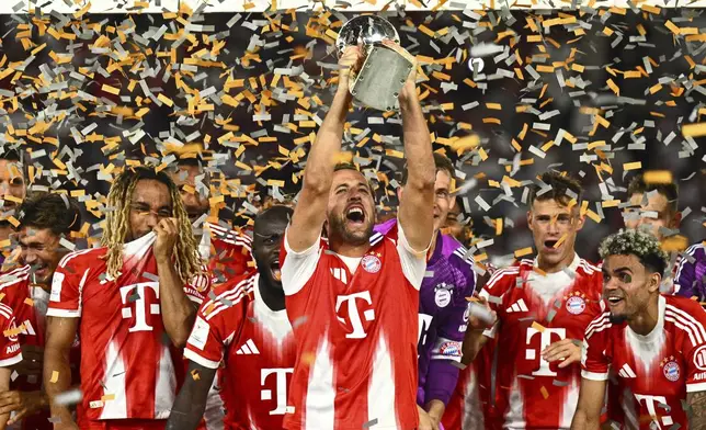 Bayern's Harry Kane celebrates with teammates after winning the German Supercup final soccer match between VfB Stuttgart and Bayern Munich in Stuttgart, Germany, Saturday, Aug. 16, 2025. (Tom Weller/dpa via AP)