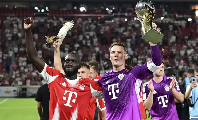 Bayern's Dayot Upamecano, left, and goalkeeper Manuel Neuer celebrate after winning the German Supercup final soccer match between VfB Stuttgart and Bayern Munich in Stuttgart, Germany, Saturday, Aug. 16, 2025. (Bernd Weissbrod/dpa via AP)