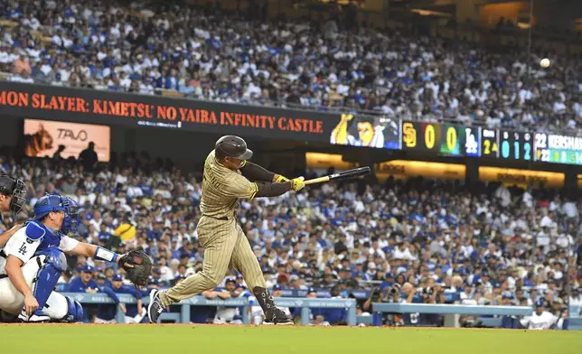 San Diego Padres' Ramon Laureano, right, hits a solo home run as Los Angeles Dodgers' Will Smith watches during the second inning of a baseball game Friday, Aug. 15, 2025, in Los Angeles. (AP Photo/Mark J. Terrill)
