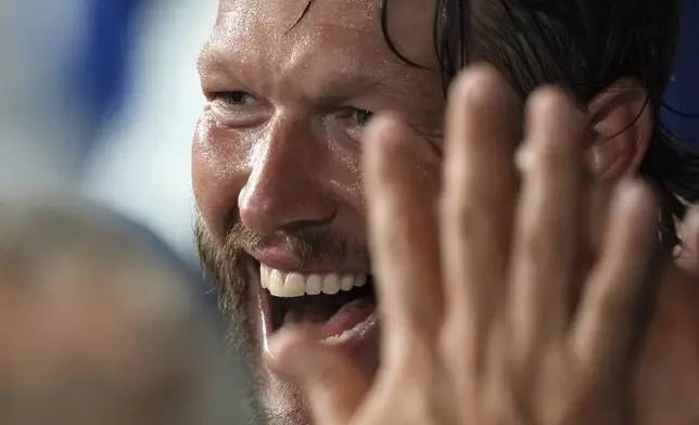 Los Angeles Dodgers starting pitcher Clayton Kershaw is congratulated by teammates in the dugout after finishing the sixth inning of a baseball game against the San Diego Padres, Friday, Aug. 15, 2025, in Los Angeles. (AP Photo/Mark J. Terrill)