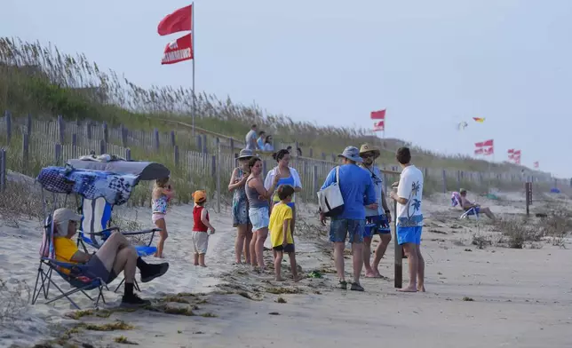 Red flags, indicating swimming is prohibited, are raised at the beach in Duck, N.C., Tuesday, Aug. 19, 2025, as precautions are taken ahead of Hurricane Erin. (AP Photo/Pablo Martinez Monsivais)