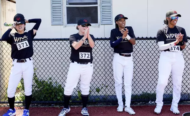 Mo'ne Davis, second from right, claps while watching other players drill during the first day of tryouts for the Women's Professional Baseball League, Friday, Aug. 22, 2025, at the Washington Nationals Youth Baseball Academy in Washington. (AP Photo/Julia Demaree Nikhinson)