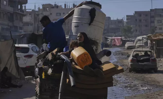 Displaced Palestinians fleeing northern Gaza Strip move with their belongings on a street in Gaza City, Thursday, Aug. 28, 2025. (AP Photo/Abdel Kareem Hana)