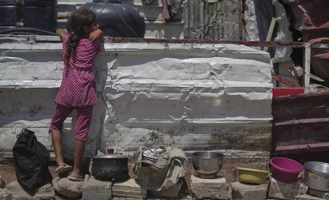 A Palestinian girl waits at a community kitchen before donated food is distributed in Gaza City, Friday, Aug. 22, 2025. (AP Photo/Abdel Kareem Hana)