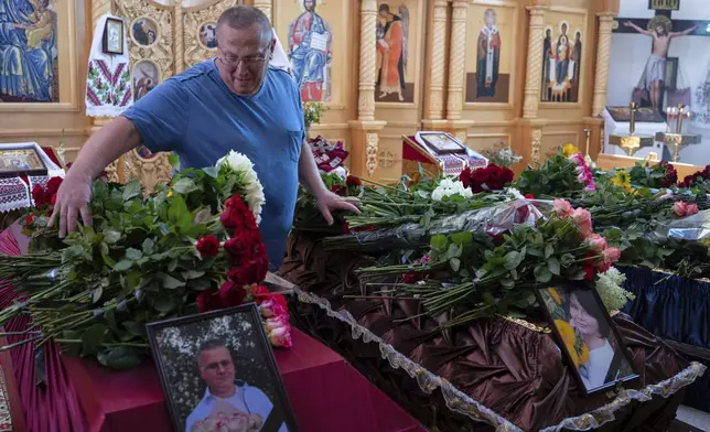 CAPTION CORRECTS THE SPELLING - Dmytro Haiova at the funeral of his sons Vladyslav and Roman, his wife Natalia and her brother Oleksandr, who were killed in their apartment in Kyiv during the Russian strike on July 31, in Ivankovychi, Kyiv region, Ukraine, Tuesday, Aug. 5, 2025. (AP Photo/Danylo Antoniuk)