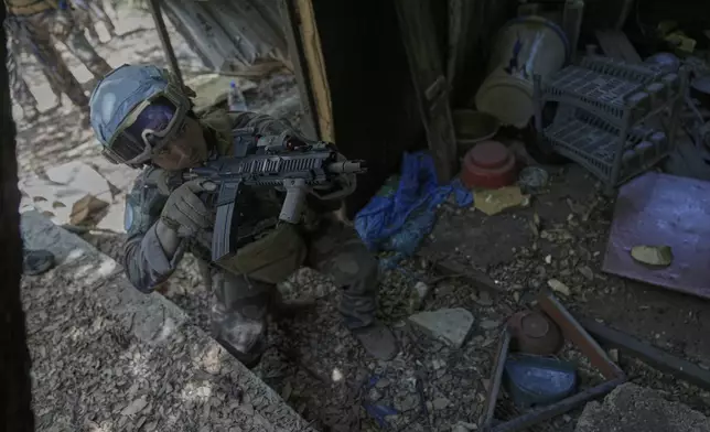 A French U.N. peacekeeper takes position as he enters a damaged room once used by Hezbollah fighters in the Saluki Valley, south Lebanon, Wednesday, Aug. 20, 2025. (AP Photo/Hussein Malla)