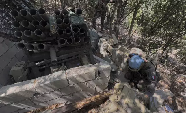 A French U.N. peacekeeper, foreground, checks ammunition boxes next to a destroyed Hezbollah rocket launcher in the Saluki Valley, south Lebanon, Wednesday, Aug. 20, 2025. (AP Photo/Hussein Malla)