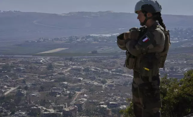 A French U.N. peacekeeper stands on a hill overlooking Kfar Kila, a Lebanese border village destroyed by Israeli airstrikes and a ground offensive, in south Lebanon, Wednesday, Aug. 20, 2025. (AP Photo/Hussein Malla)