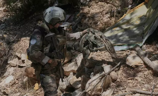 A French U.N. peacekeeper inspects a destroyed Hezbollah position in the Saluki Valley, south Lebanon, Wednesday, Aug. 20, 2025. (AP Photo/Hussein Malla)"