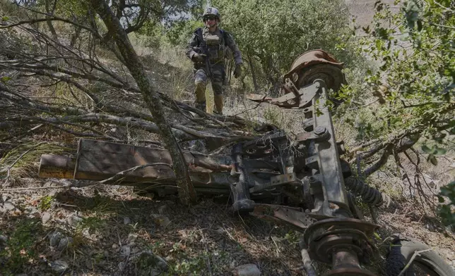 A French U.N. peacekeeper walks past a destroyed Hezbollah artillery cannon in the Saluki Valley, south Lebanon, Wednesday, Aug. 20, 2025. (AP Photo/Hussein Malla)