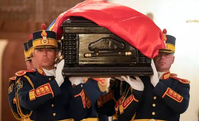 Honor guard soldiers carry the coffin of the late Ion Iliescu, Romania's first freely elected president after the fall of communism in 1989, at the Cotroceni Presidential Palace, in Bucharest, Romania, Wednesday, Aug. 6, 2025.(AP Photo/Vadim Ghirda)