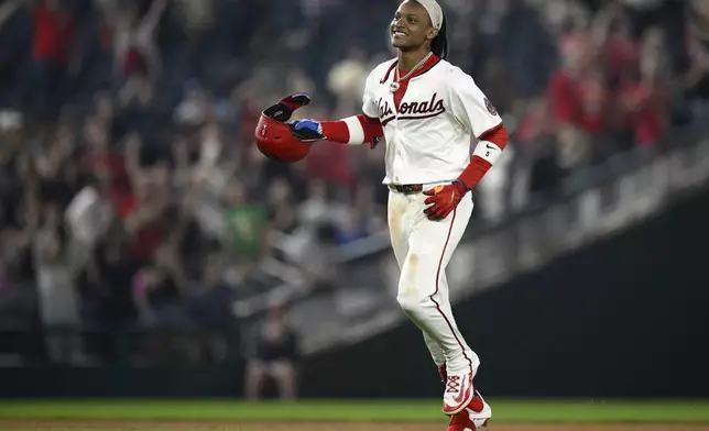 Washington Nationals' CJ Abrams celebrates after he hit a walk-off single to score Robert Hassell III for the game-winning run during the ninth inning of a baseball game against the Athletics, Wednesday, Aug. 6, 2025, in Washington. (AP Photo/Nick Wass)