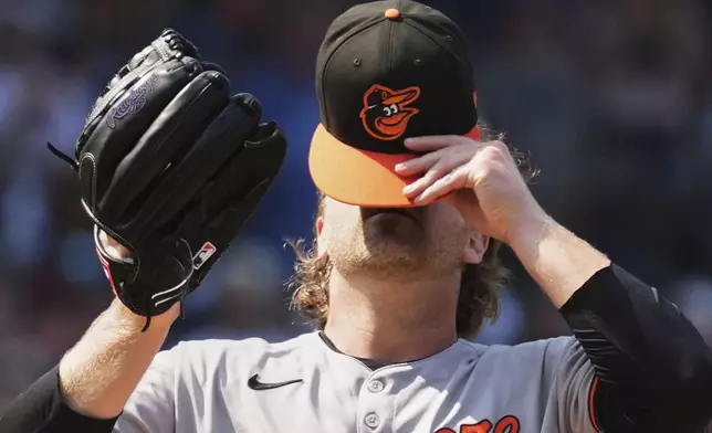 Baltimore Orioles relief pitcher Dietrich Enns takes off his cap during the sixth inning of a baseball game against the Chicago Cubs in Chicago, Sunday, Aug. 3, 2025. (AP Photo/Nam Y. Huh)