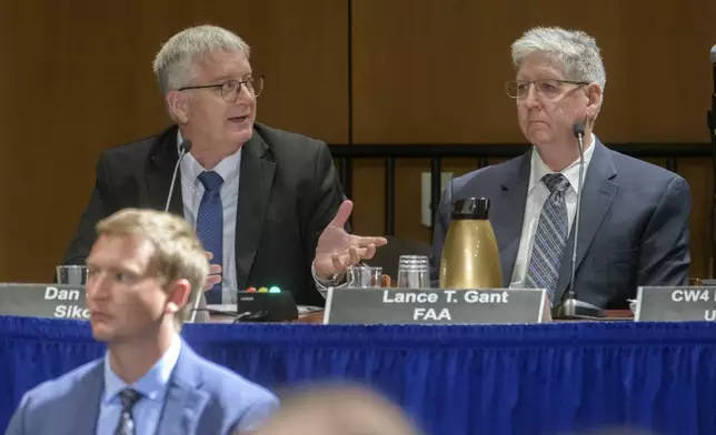 Lance Gant, right, of the Federal Aviation Administration, listens as Dan Cooper, left, of Sikorsky Aircraft, responds to questions during the NTSB fact-finding hearing on the DCA midair collision accident, at the National Transportation and Safety Board boardroom, Wednesday, July 30, 2025, in Washington. (AP Photo/Rod Lamkey, Jr.)