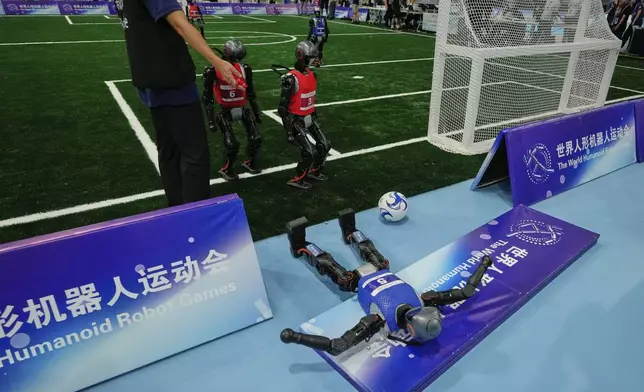 A robot crashes during a soccer match at the World Humanoid Robot Games in Beijing, China, Friday, Aug. 15, 2025. (AP Photo/Mahesh Kumar A.)