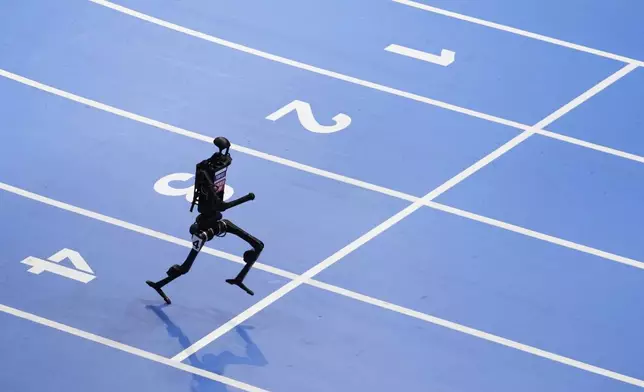 A robot competes in the 1500m race during the World Humanoid Robot Games in Beijing, China, Friday, Aug. 15, 2025. (AP Photo/Mahesh Kumar A.)