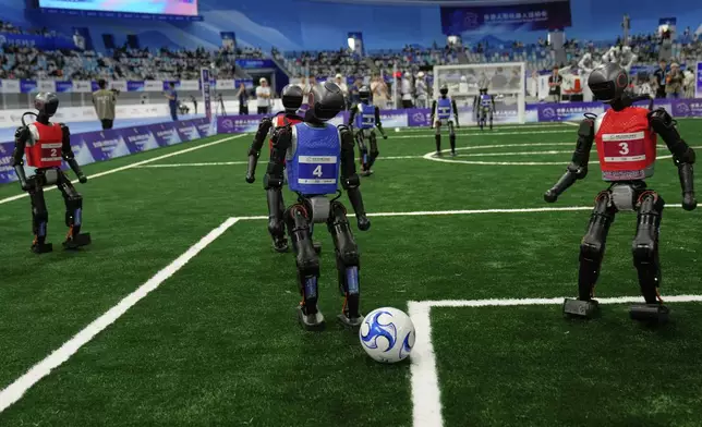 Robots play soccer at the World Humanoid Robot Games in Beijing, China, Friday, Aug. 15, 2025. (AP Photo/Mahesh Kumar A.)