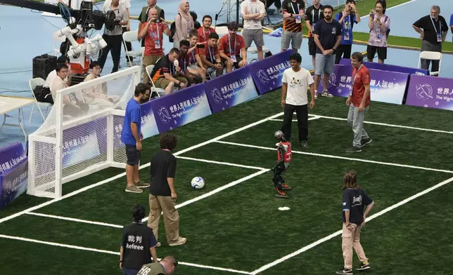 A robot stands in front of the net at a soccer demonstration match between humans vs robots during the closing ceremony of the World Humanoid Robot Games held in Beijing, China, Sunday, Aug. 17, 2025. (AP Photo/Mahesh Kumar A.)