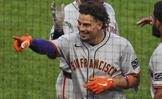 San Francisco Giants' Willy Adames points to the stands as he returns to the dugout after hitting a two-run home run off Pittsburgh Pirates pitcher Mike Burrows during the fifth inning of a baseball game in Pittsburgh, Tuesday, Aug. 5, 2025. (AP Photo/Gene J. Puskar)
