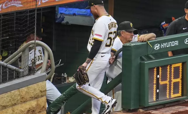 Pittsburgh Pirates pitcher Mike Burrows, center, walks down the dugout steps past coach Gene Lamont, right, after being removed in the fifth inning of a baseball game against the San Francisco Giants in Pittsburgh, Tuesday, Aug. 5, 2025. (AP Photo/Gene J. Puskar)