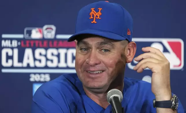 New York Mets manager Carlos Mendoza talks with reporters before the Little League Classic baseball game against the Seattle Mariners at Bowman Field in Williamsport, Pa., Sunday, Aug. 17, 2025. (AP Photo/Gene J. Puskar)