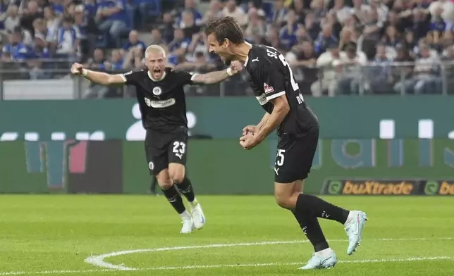 FC St. Pauli's Adam Dzwigala, right, celebrates after scoring a goal during the German Bundesliga soccer match between Hamburger SV and FC St. Pauli at Volksparkstadion in Hamburg, Germany, Friday, Aug. 29, 2025. (Marcus Brandt/dpa via AP)