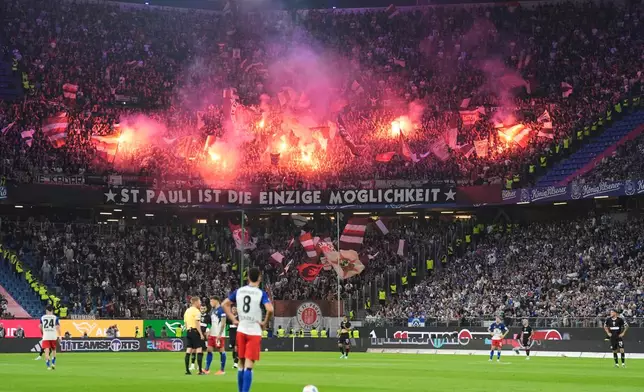 St. Pauli fans set off fireworks in the stands during the German Bundesliga soccer match between Hamburger SV and FC St. Pauli at Volksparkstadion in Hamburg, Germany, Friday, Aug. 29, 2025. (Christian Charisius/dpa via AP)