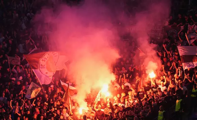 St. Pauli fans set off fireworks in the stands during the German Bundesliga soccer match between Hamburger SV and FC St. Pauli at Volksparkstadion in Hamburg, Germany, Friday, Aug. 29, 2025. (Marcus Brandt/dpa via AP)