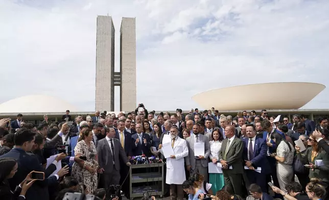 Senators and deputies allied with former Brazilian President Jair Bolsonaro hold a press conference outside the National Congress in Brasília, Tuesday, Aug. 5, 2025, to denounce the house arrest order issued against Bolsonaro by Supreme Court Justice Alexandre de Moraes. (AP Photo/Eraldo Peres)