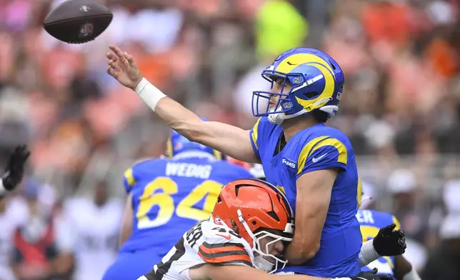Cleveland Browns linebacker Carson Schwesinger (49) tackles Los Angeles Rams quarterback Dresser Winn (4) in the first half of an NFL preseason football game Saturday, Aug. 23, 2025, in Cleveland. (AP Photo/David Richard)