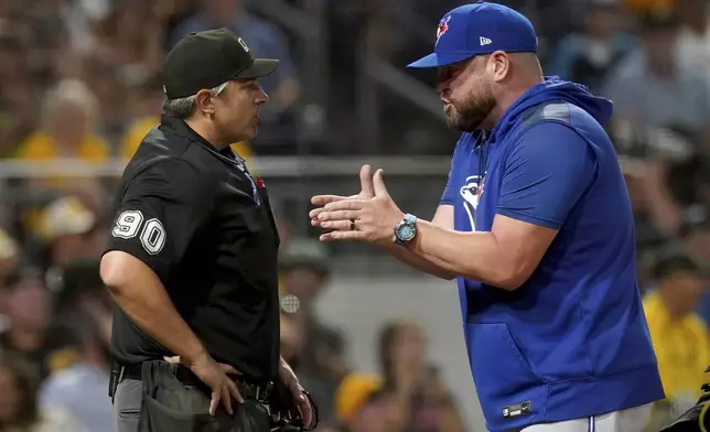Toronto Blue Jays manager John Schneider, right, argues with home plate umpire Mark Ripperger, left, after Schneider was thrown out during the seventh inning of a baseball game against the Pittsburgh Pirates, Monday, Aug. 18, 2025, in Pittsburgh. (AP Photo/Matt Freed)