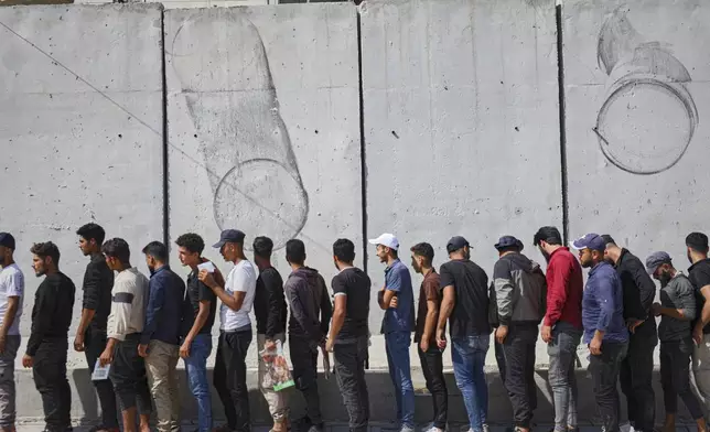 Young Kurdish men line up to sign up to join Syrian government's General Security forces at a police station in Afrin, Syria, an area in the country's north from which Kurds were forcibly displaced years ago, Thursday Aug. 21, 2025. (AP Photo/Omar Albam)