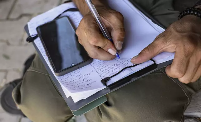 A Kurdish man signs up to join the Syrian government's General Security forces at a police station in Afrin, Syria, an area in the country's north from which Kurds were forcibly displaced years ago, Thursday Aug. 21, 2025. (AP Photo/Omar Albam)
