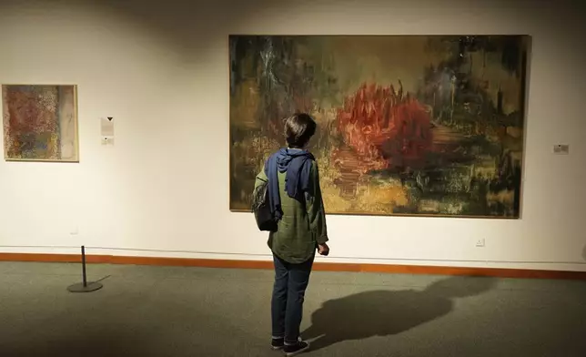 A woman visits an exhibition called "In Women's Words" showing some artworks of modern Iranian women artists from the collection of the Tehran Museum of Contemporary Art, Iran, Sunday, Aug. 3, 2025. (AP Photo/Vahid Salemi)